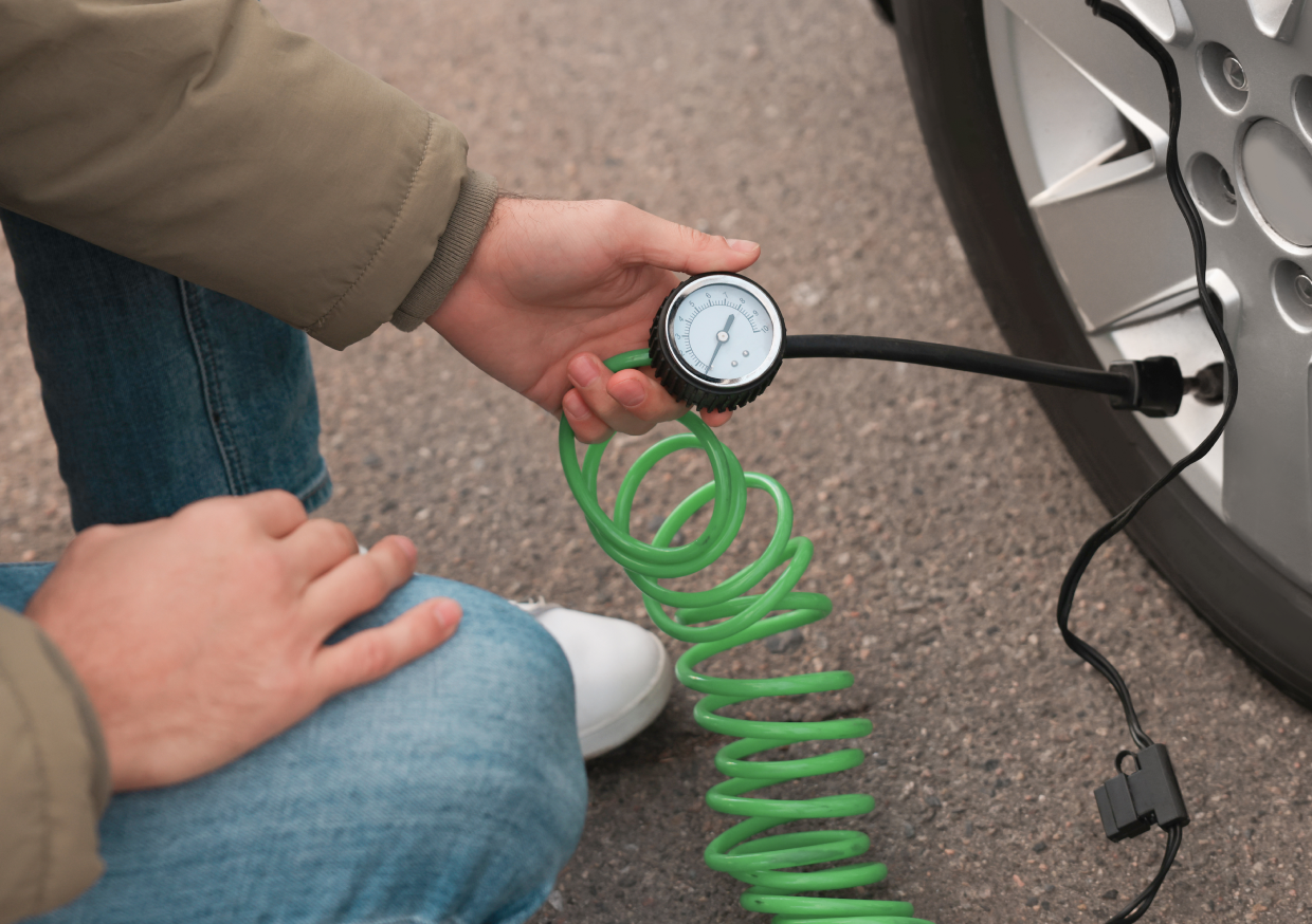 Person checking tire pressure with gauge.