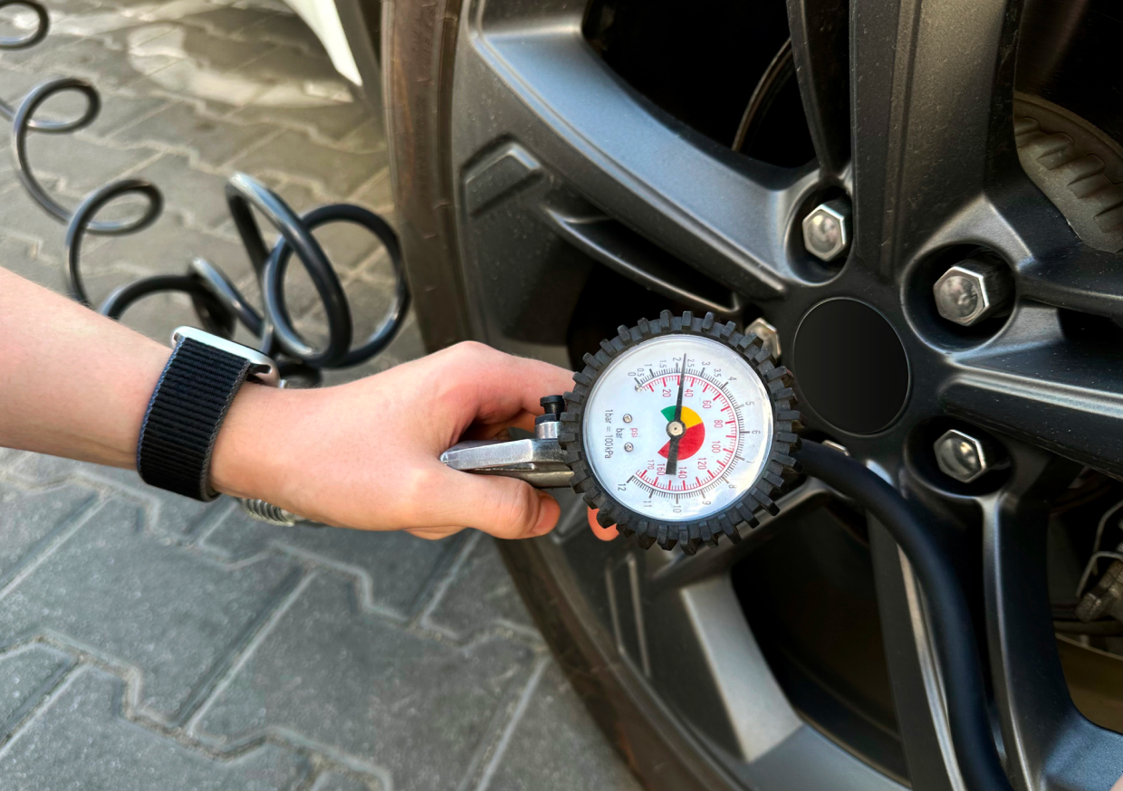 Checking car tire pressure with gauge.